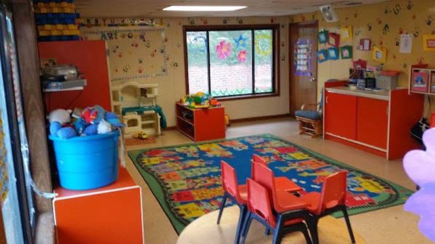 Playroom with alphabet rug, red chairs, and art displays