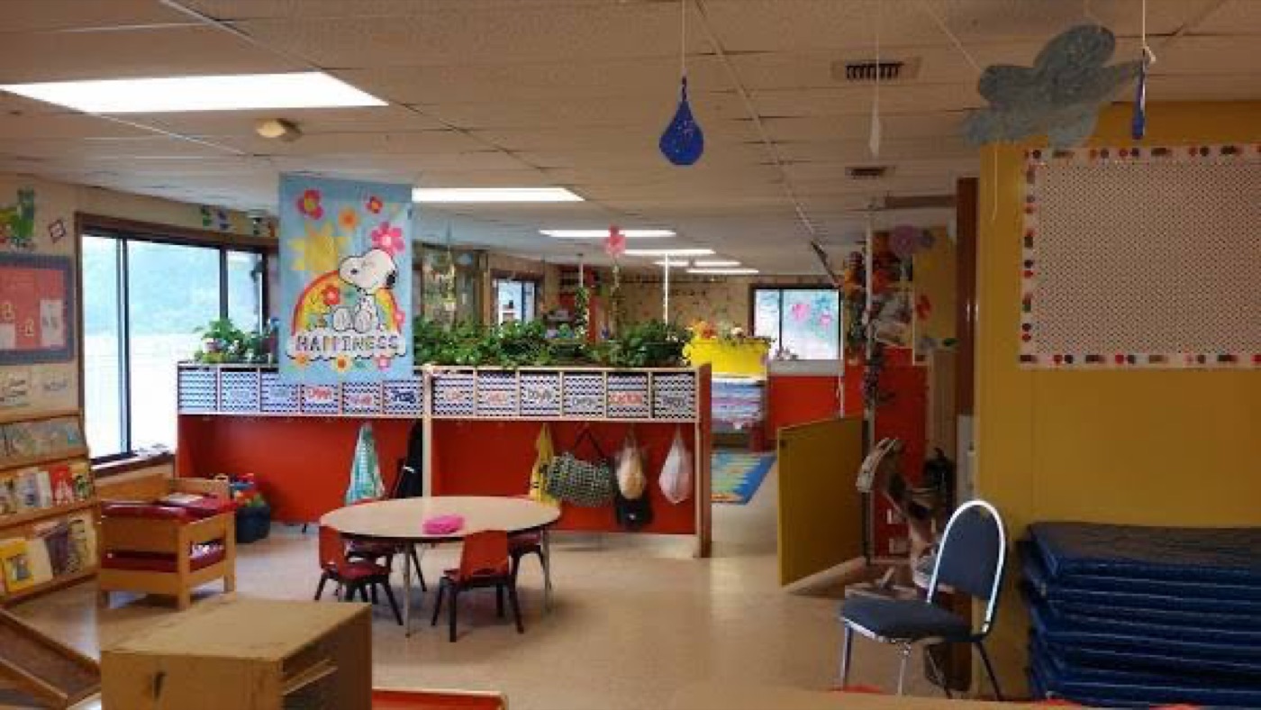 Classroom with round table, cubbies, and natural light from large windows
